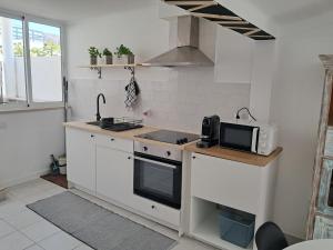 a kitchen with a sink and a microwave at Casas da Praia in Foz do Arelho