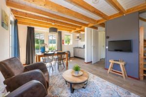 a living room with a couch and a table at Sfeervolle Zeeuwse Cottage met extra slaapkamer 4 personen in Wemeldinge