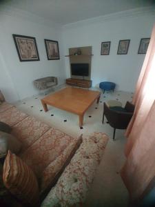 a living room with a couch and a table at R flaurence la marsa in El Haouach