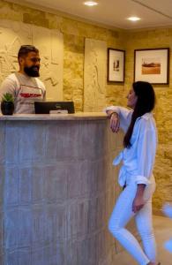 a woman standing next to a bar with a man at Bedouin Camp pyramids view INN in Cairo