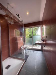 a bathroom with a shower and a toilet and a sink at Le Tuc Lodge in Messanges +38 photos