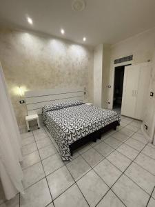 a bedroom with a large bed in a room with tile floors at Pollon Inn Sanremo in Sanremo +5 photos