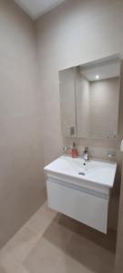 a white bathroom with a sink and a mirror at S2 apartment with sea view Costa Chatt Mariam in Chott Meriem +29 photos