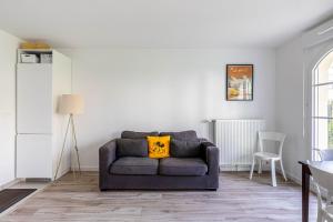 Una sala de estar con un sofá con una almohada amarilla. en GuestReady - Charming getaway near Disneyland, en Marne-la-Vallée 6 fotos más