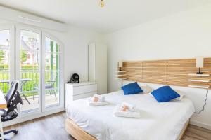 Un dormitorio con una cama grande con almohadas azules. en GuestReady - Charming getaway near Disneyland, en Marne-la-Vallée