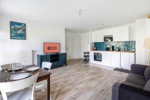 Una sala de estar con una mesa y una cocina. en GuestReady - Charming getaway near Disneyland, en Marne-la-Vallée