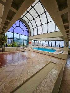a swimming pool in a building with a glass ceiling at EstanPlaza Nações Unidas - SP Classic - apto 302 in Sao Paulo