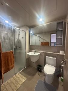 a bathroom with a toilet and a sink and a shower at Spacious Condo in Clark! Free Parking in Fort Stotsenburg