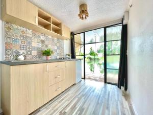a kitchen with wooden cabinets and a large window at Lake House in Vadu Crişului