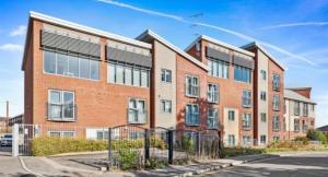 a brick building with a fence in front of it at Contractor-Friendly, Private Gated Parking, Fast WiFi, Sofa Bed & Netflix, 5-Min Walk to City Centre, 15-Min Walk to Train Station, Ideal for Relocators & Families in Coventry