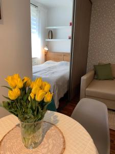 a vase of yellow flowers sitting on a table at Apartament Ogrodowa in Bielany Wrocławskie