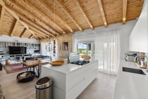 an open kitchen with white cabinets and a table at Villa Puccini with pool and sauna in Frata