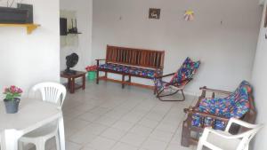 a living room with chairs and a table and a bench at Casa Mosqueiro in Mosqueiro