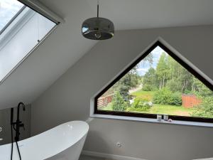 a bathroom with a large window and a bath tub at Dom przy Lesie in Augustów +11 photos