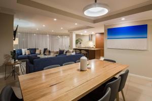 a living room with a dining table and a living room at 'Azure' Beachside Resort Escape for Groups in Marybrook
