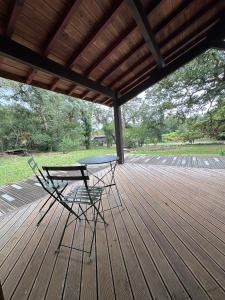 a table and a chair on a wooden deck at Le Tuc Lodge in Messanges