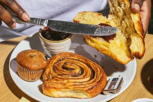 un piatto di cibo con una persona che tiene un coltello di Point A Hotel London Shoreditch a Londra