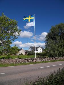 uma bandeira num poste ao lado de uma estrada em Mellby Ör Inn em Mellby