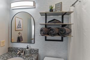 a bathroom with a sink and a mirror and towels at Dog Friendly Pool Walk to Beach in Gulf Shores +45 photos