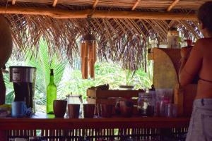 a woman standing in a bar looking out a window at ElSueño Ocean view dorm & community vibe in Playa Agua Blanca