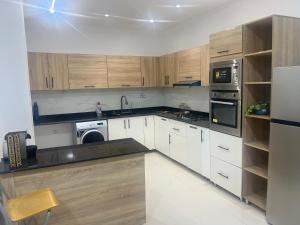 a kitchen with white cabinets and a black counter top at Apparemment neuf in Mostaganem +8 photos