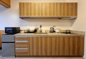 a kitchen with wooden cabinets and a sink at Loft2600 in Baguio