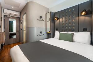 a bedroom with a large bed with a black headboard at Point A Hotel London Shoreditch in London
