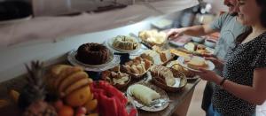 two people standing in front of a buffet of food at Hotel Pousada Iracemar - Piscina Aquecida in Guarujá