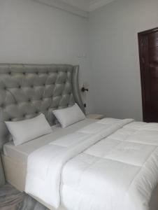 a large white bed with two pillows on it at GEFONA Guest HOUSE in Yaoundé