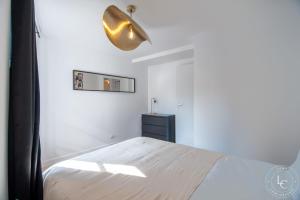 a white bedroom with a bed and a lamp at Chambord Apartment Modern comfort near the Loire castles in Courbouzon +9 photos