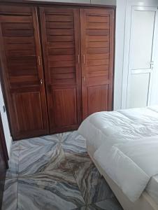 a bedroom with a bed and wooden cabinets at GEFONA Guest HOUSE in Yaoundé +14 photos
