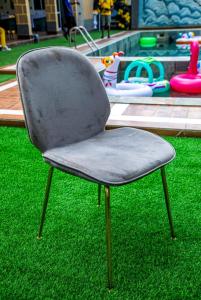 a gray chair sitting on the grass in a yard at GEFONA Guest HOUSE in Yaoundé