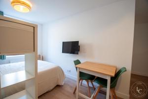 a bedroom with a desk and a bed and a table and chairs at Le Blois Apartment Modern comfort near the Loire castles in Courbouzon