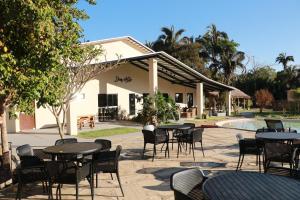 a group of tables and chairs in front of a building at Pousada Casa de Naná in Palmas