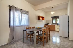 a kitchen with a table and chairs and a refrigerator at Kastelli retreat in Lákkoma