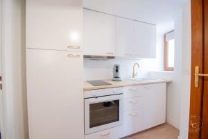 a white kitchen with a refrigerator and a sink at Le Cheverny Apartment Cozy stay near the Loire castles in Courbouzon