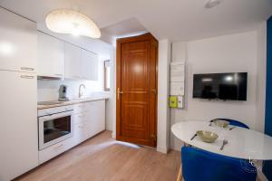 a kitchen with white cabinets and a wooden door at Le Cheverny Apartment Cozy stay near the Loire castles in Courbouzon
