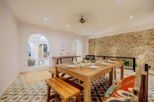 a dining room with a table and a stone wall at La Dominica Hotel Boutique in Cartagena de Indias