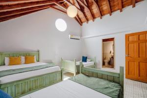 a bedroom with two beds and a wooden door at La Dominica Hotel Boutique in Cartagena de Indias +221 photos