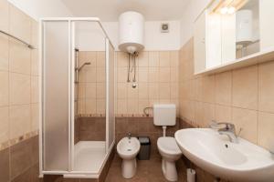 un bagno con doccia, lavandino e WC di Apartment Vrba a Supetar (San Pietro di Brazza) Altre 19 foto