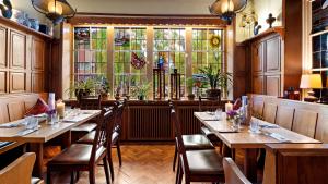 ein Restaurant mit Holztischen und -stühlen und einem Fenster in der Unterkunft Altes Gasthaus Kuhr - Hotel & Restaurant in Papenburg