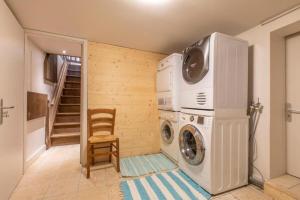 een wasmachine en droger in een kamer met een trap bij Beautiful Lake Annecy Villa in Menthon-Saint-Bernard