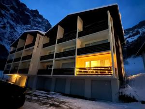 a building in the snow with mountains in the background at Leukerbad TOP, Thermalquellen, Skigebiet in Leukerbad