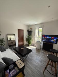 a living room with a couch and a table at Appartement entier dans résidence in Asnières-sur-Seine