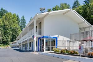 a white building with a blue door in a parking lot at Motel 6-Kelso, WA - Mt. St. Helens in Kelso