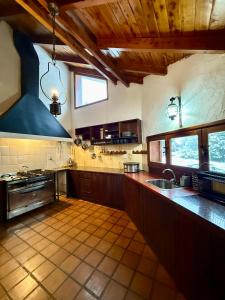 a large kitchen with a sink and a stove at Nevada Hostel in San Carlos de Bariloche