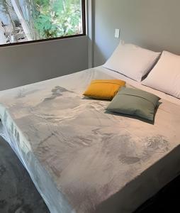 a bed with two pillows on it in a room at Itacaré Ecolodge - Experiencia de Imersão na Mata Atlântica in Itacaré