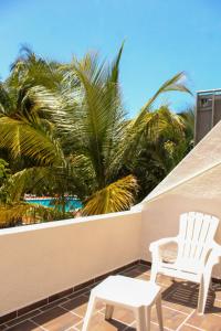 a patio with two white chairs and a palm tree at Sea Bloom in Cancún +27 photos