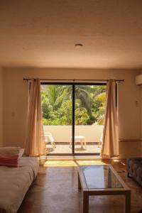 a living room with a large window and a glass table at Sea Bloom in Cancún