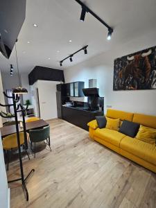a living room with a yellow couch and a table at Bear Homes - Olimpia Suite in Valencia
